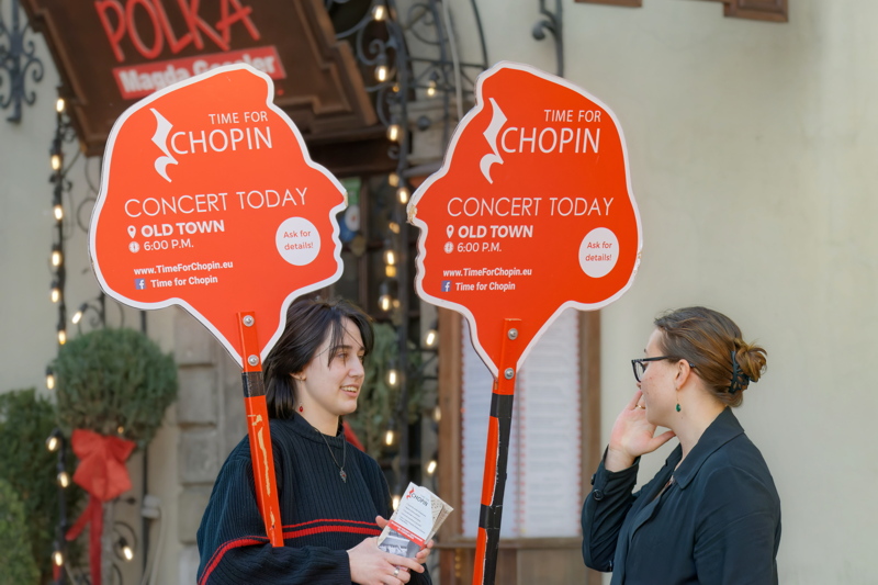 23 - A street promotion in Warsaw, Poland, featuring branded red signs for daily live piano recitals celebrating the legacy of Frédéric Chopin